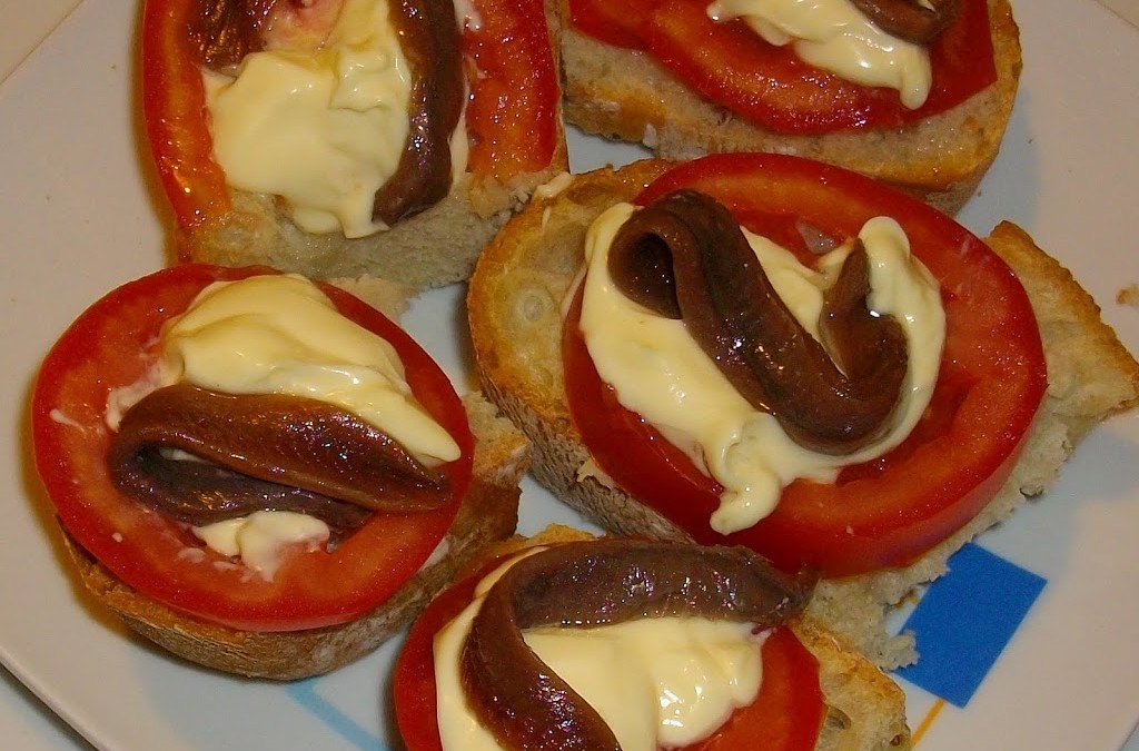 Tapa con anchoas, tomate y aceite oliva